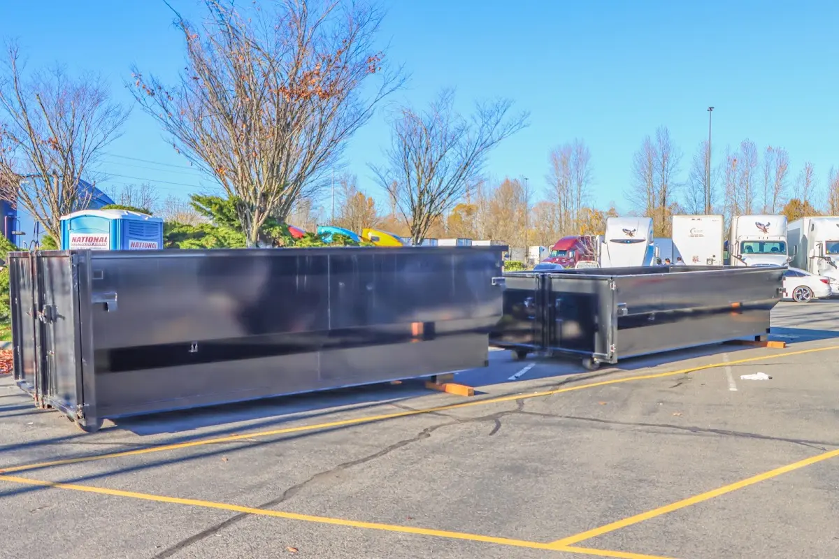 Professional dumpster rental service with roll-off container on residential driveway in Bar Harbor